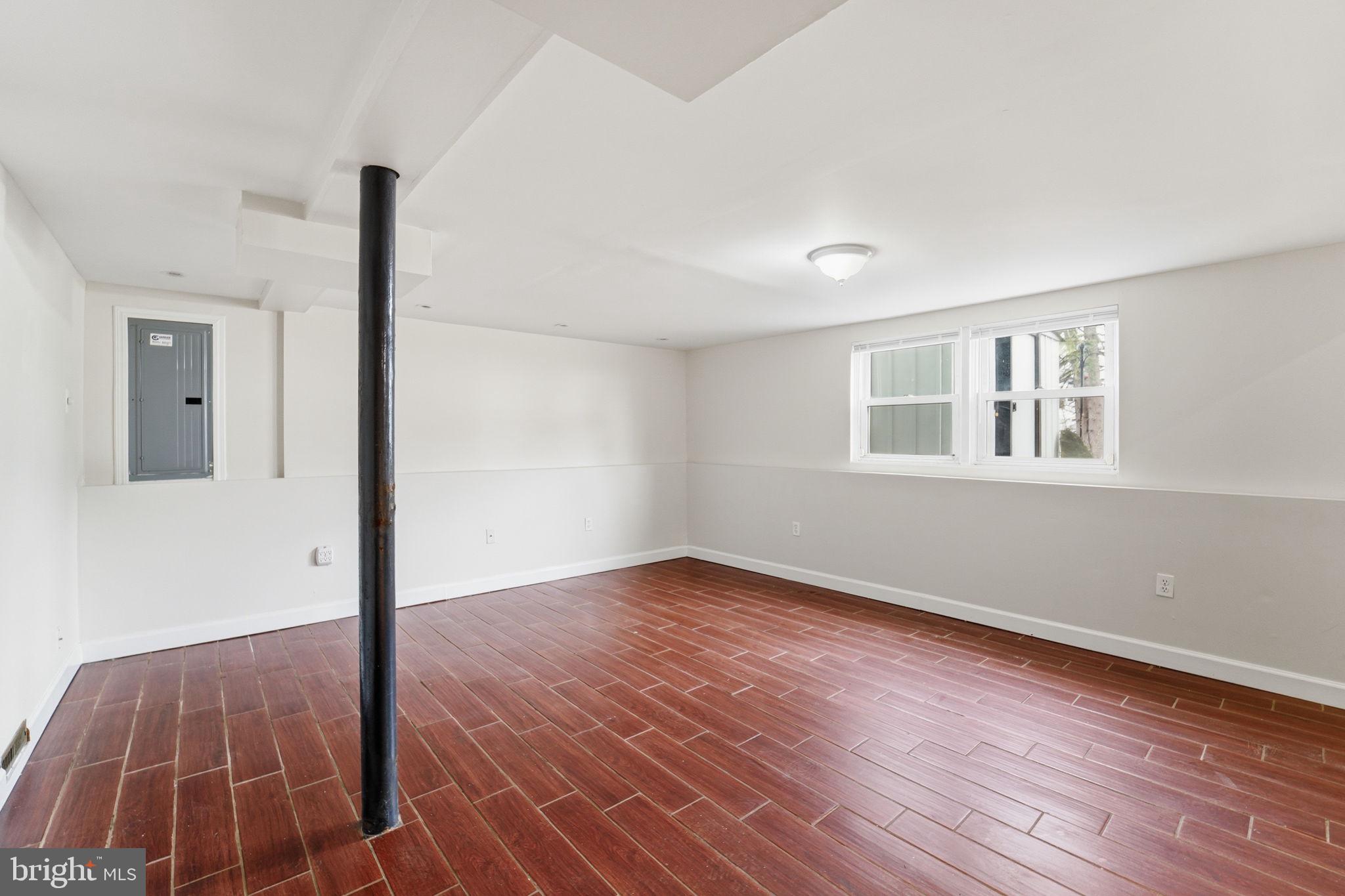 490 Hamilton Road Wenonah, NJ 08090 - Photo 26 of 49 a view of an empty room with wooden floor and a window