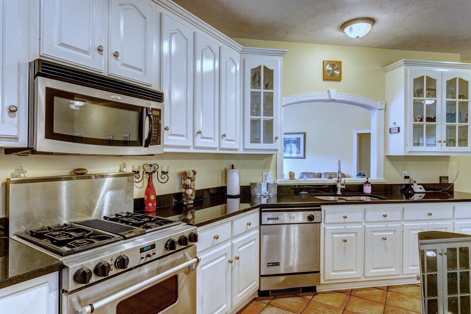 7571 Webster Road White House, TN 37188 - Photo 12 of 30 a kitchen with stainless steel appliances granite countertop a stove a microwave and cabinets