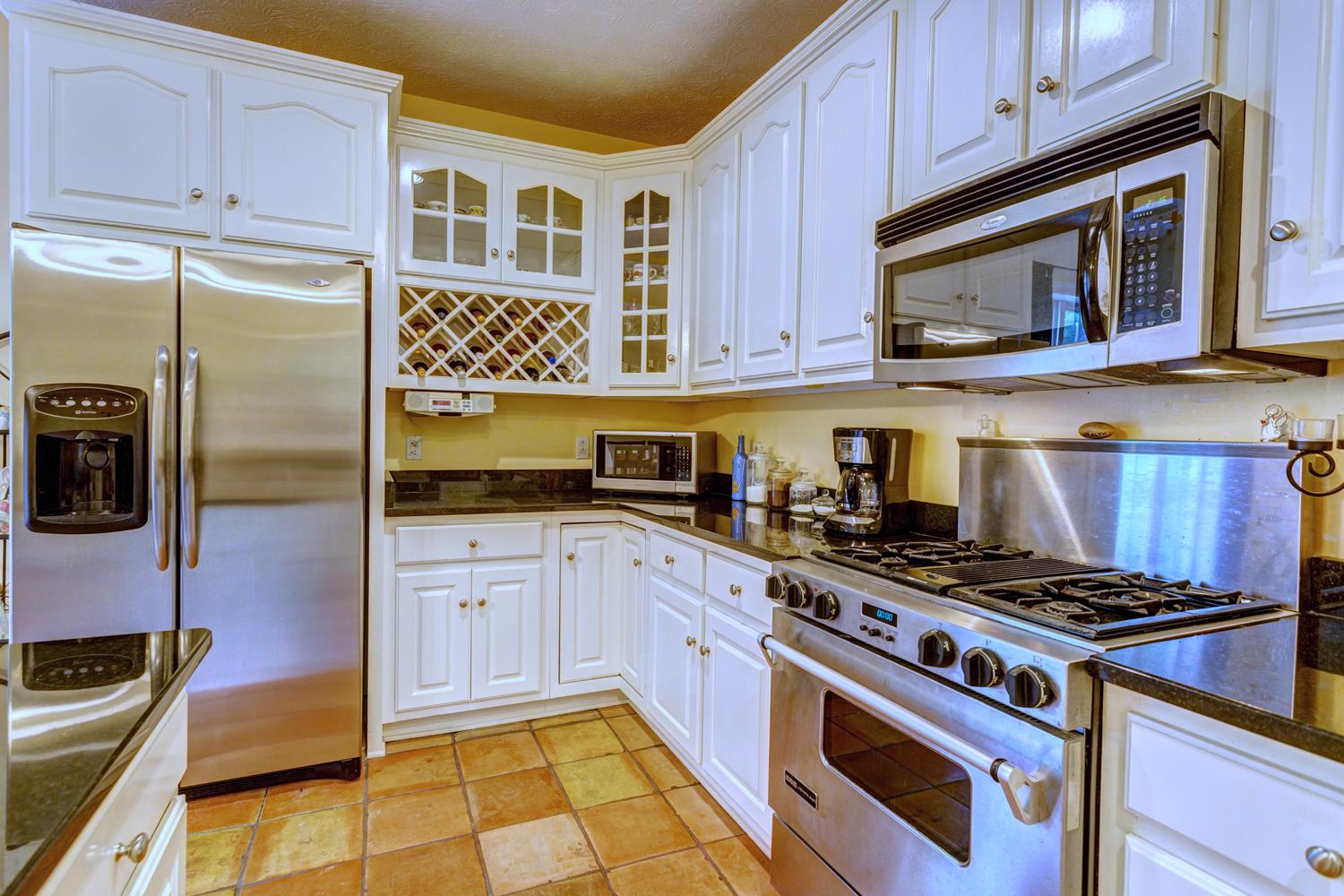 7571 Webster Road White House, TN 37188 - Photo 13 of 30 a kitchen with stainless steel appliances a stove a microwave and cabinets