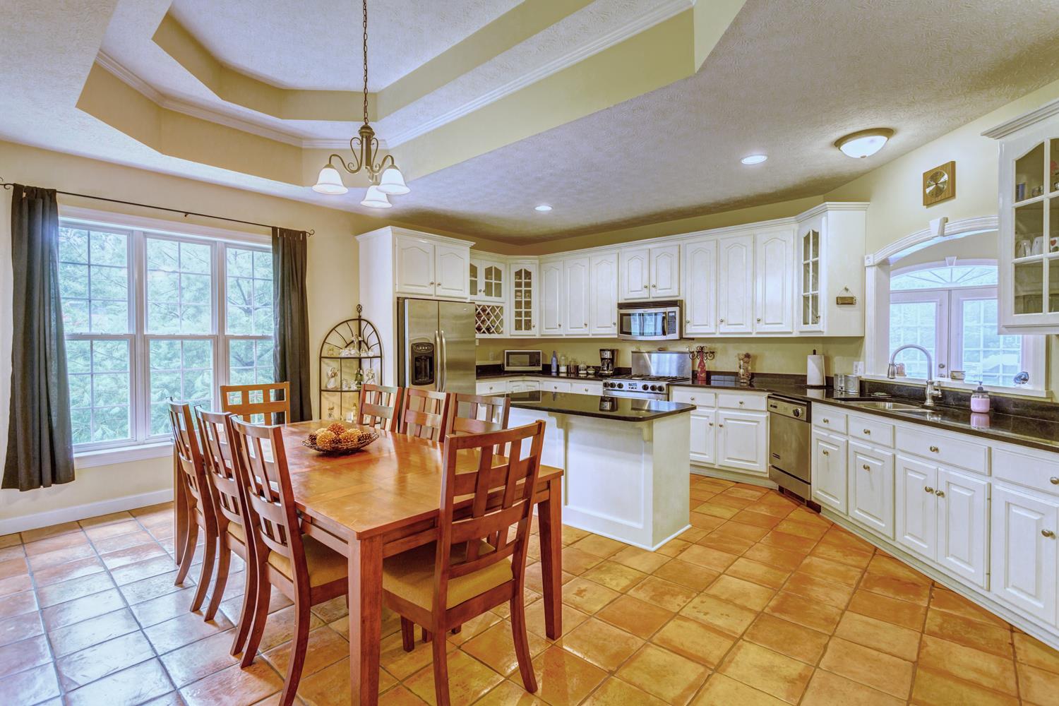 7571 Webster Road White House, TN 37188 - Photo 10 of 30 a kitchen with stainless steel appliances granite countertop a sink a stove a dining table and chairs