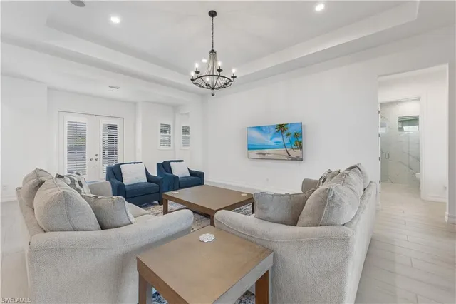 a spacious bedroom with a bed and a chandelier