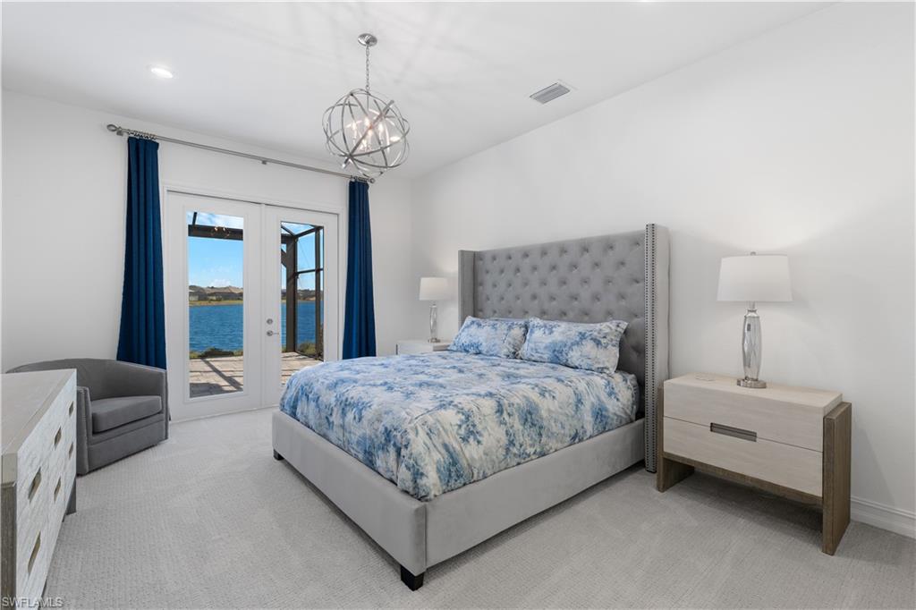 14265 Laguna Springs Lane Naples, FL 34114 - Photo 12 of 40 a spacious bedroom with a bed and a chandelier