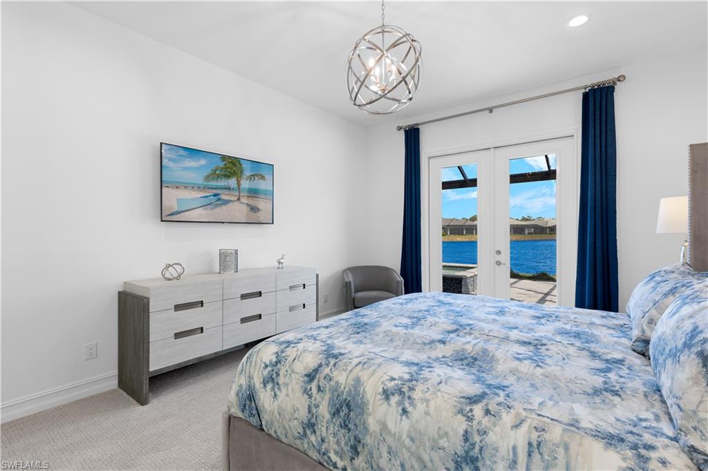 14265 Laguna Springs Lane Naples, FL 34114 - Photo 13 of 40 a bedroom with a bed and a chandelier