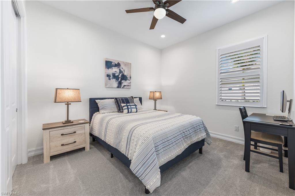 14265 Laguna Springs Lane Naples, FL 34114 - Photo 19 of 40 a bedroom with a bed and a table