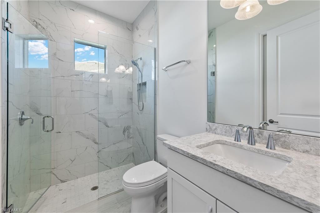 14265 Laguna Springs Lane Naples, FL 34114 - Photo 20 of 40 a bathroom with a granite countertop sink toilet and shower