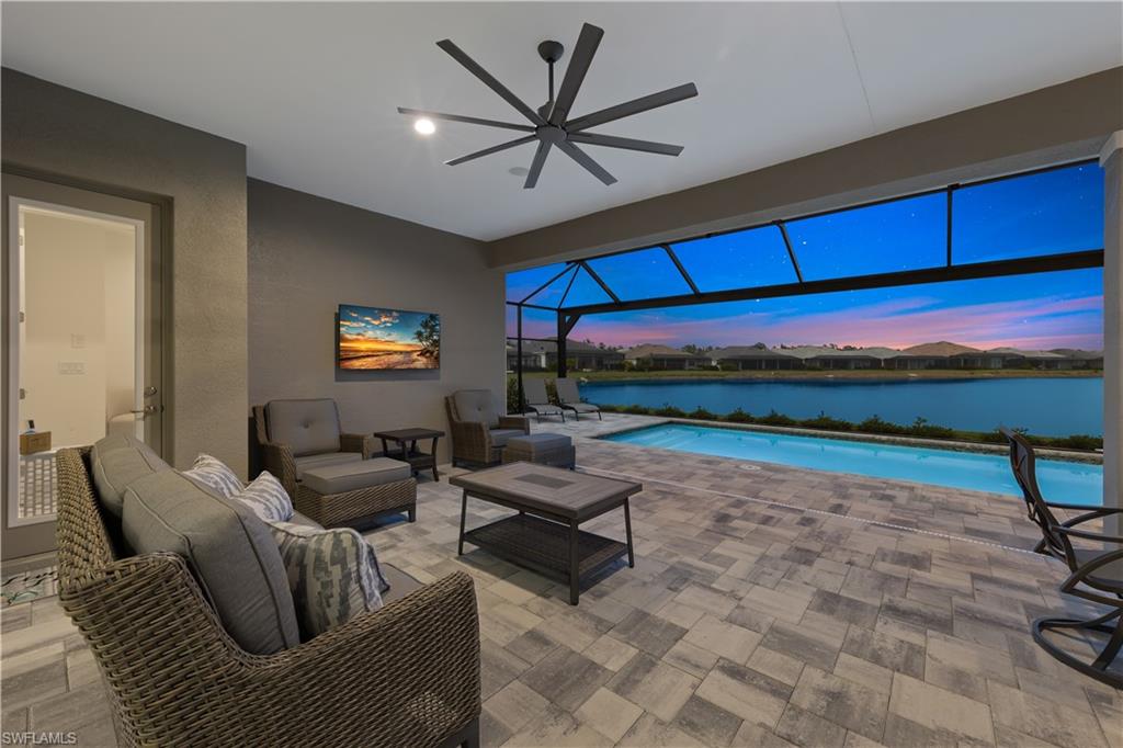 14265 Laguna Springs Lane Naples, FL 34114 - Photo 30 of 40 a living room with furniture a rug and a floor to ceiling window