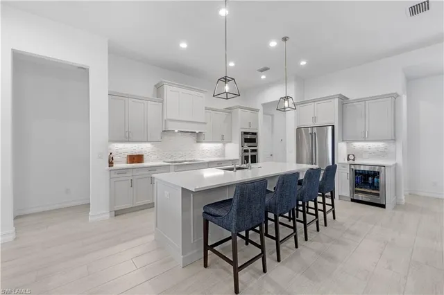 a kitchen with stainless steel appliances granite countertop a stove a sink a oven a dining table and chairs