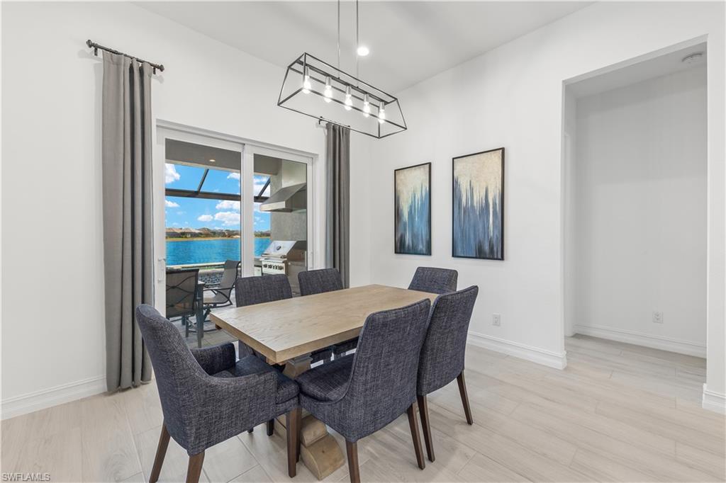 14265 Laguna Springs Lane Naples, FL 34114 - Photo 6 of 40 a view of a dining room with furniture a chandelier and wooden floor