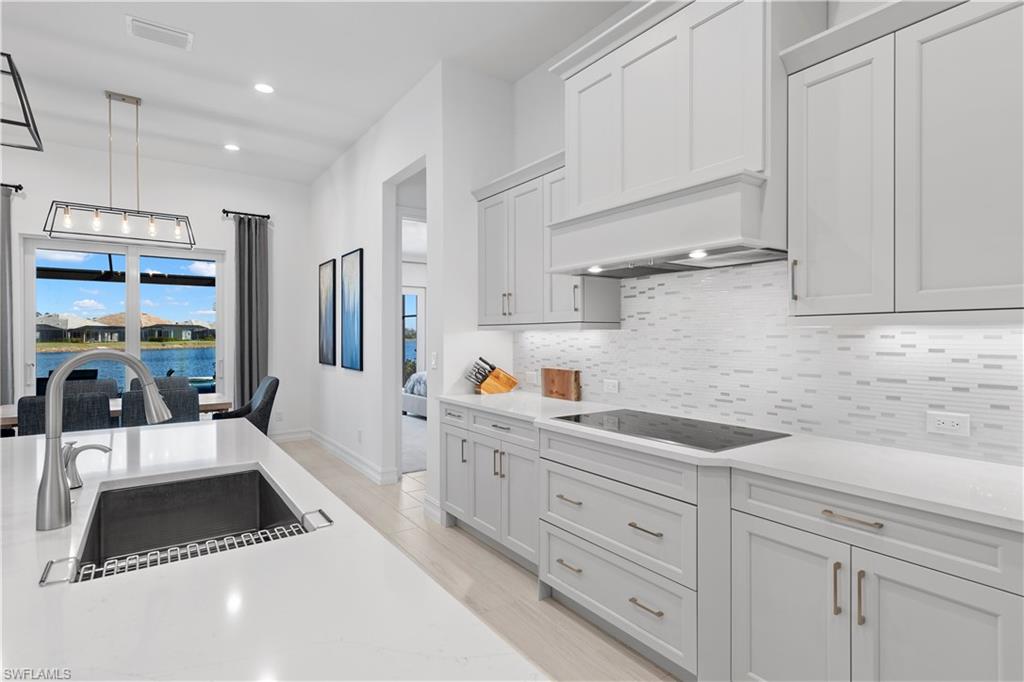 14265 Laguna Springs Lane Naples, FL 34114 - Photo 8 of 40 a kitchen with white cabinets and window
