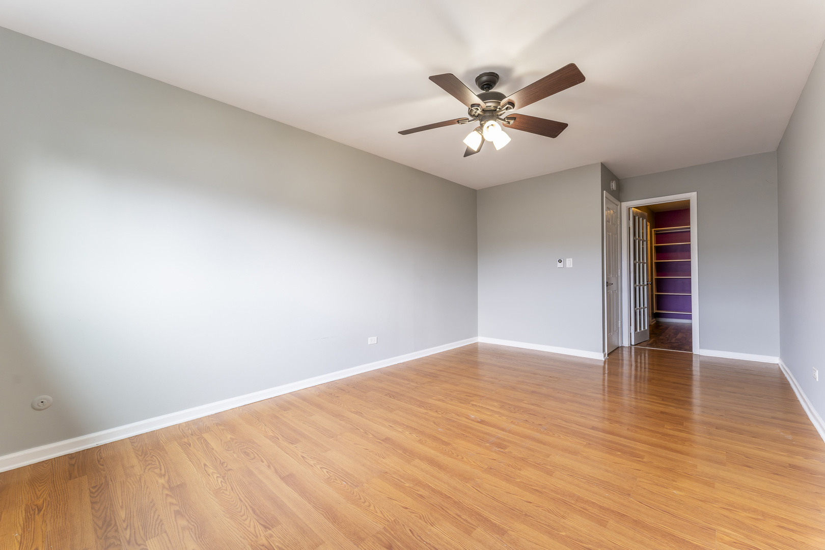 802 East Old Willow Road, Unit 114 Prospect Heights, IL 60070 - Photo 9 of 14 a view of an empty room with wooden floor and a ceiling fan