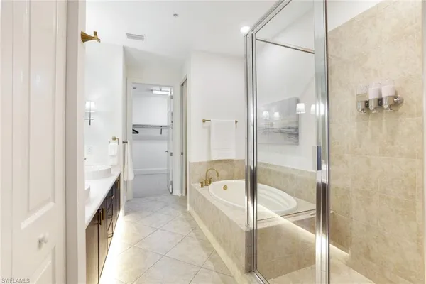 a bathroom with a granite countertop tub sink a shower and a mirror
