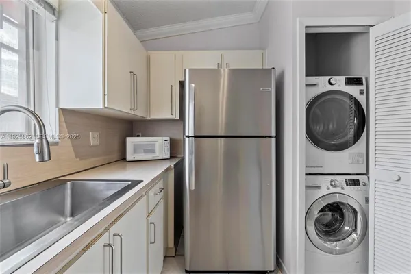 a kitchen with white cabinets and appliances