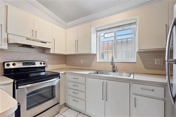 a kitchen with white cabinets and appliances