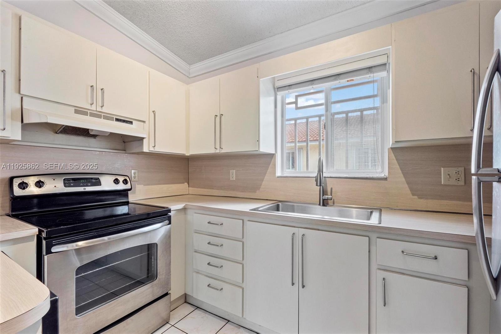 10101 West Okeechobee Road, Unit 13202 Hialeah Gardens, FL 33016 - Photo 17 of 30 a kitchen with white cabinets and appliances
