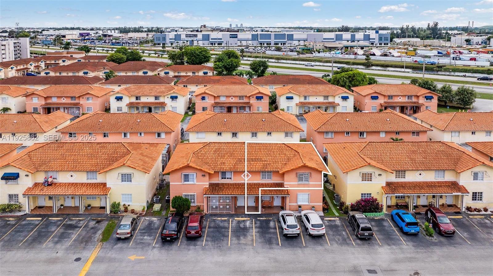 10101 West Okeechobee Road, Unit 13202 Hialeah Gardens, FL 33016 - Photo 5 of 30 an aerial view of a building with parked cars