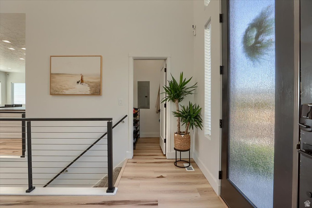 828 South Deer Road Tooele, UT 84074 - Photo 6 of 51 Entryway featuring light wood-finish flooring and a contemporary black metal railing with horizontal balusters