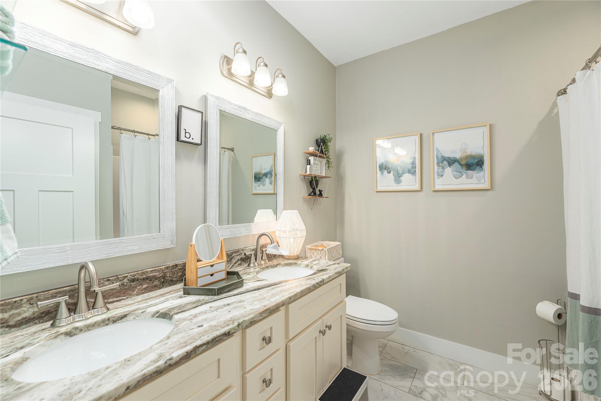 348 Olivet Lane Fletcher, NC 28732 - Photo 23 of 39 a bathroom with a granite countertop toilet a sink and a mirror