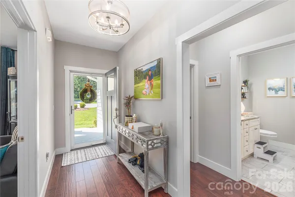 a view of a hallway to a livingroom and a dining room with furniture