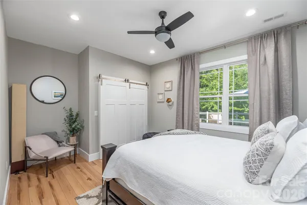a spacious bedroom with a bed and a chandelier