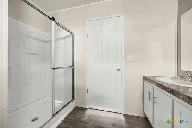 a bathroom with a granite countertop shower and a sink