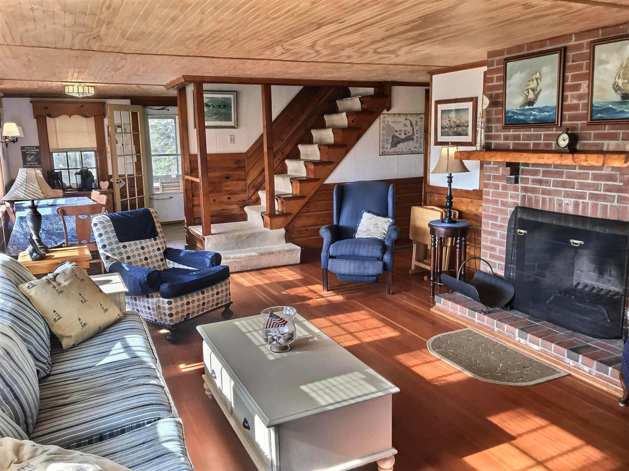 345 Shurtleff Road Eastham, MA 02642 - Photo 8 of 23 a living room with furniture a fireplace and a table