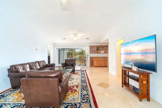 a living room with furniture and a view of kitchen