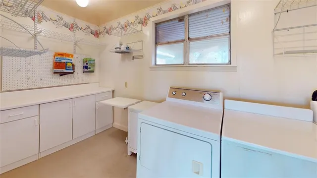 a utility room with cabinets washer and dryer
