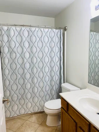 a white toilet sitting next to a white wall