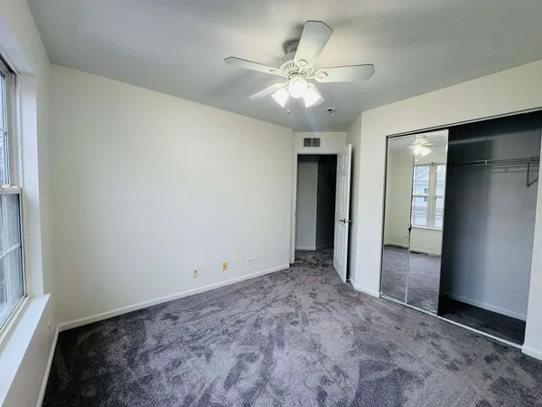 an empty room with fan and entrance