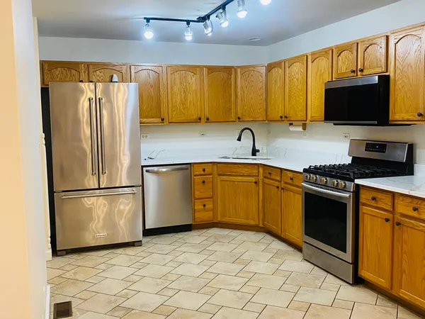 a kitchen with stainless steel appliances granite countertop a stove a sink and a refrigerator