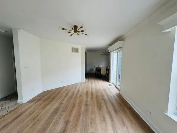 a view of empty room with wooden floor and ceiling fan