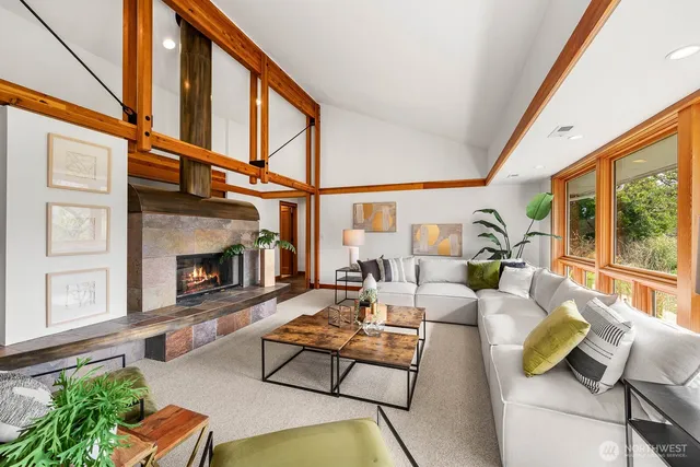 a living room with furniture a fireplace and a floor to ceiling window