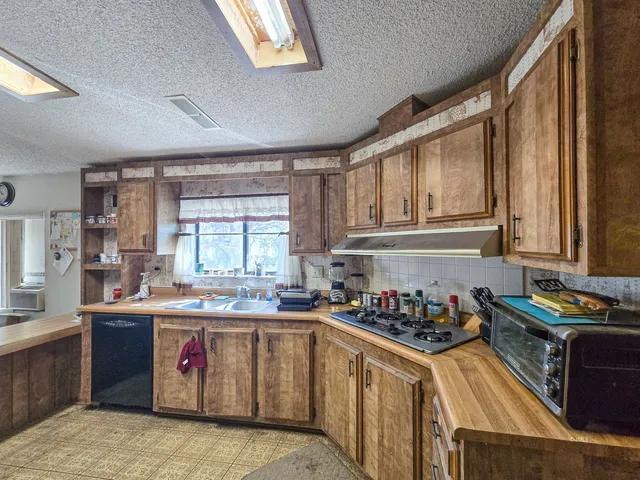 a kitchen with a sink stove top oven and cabinets