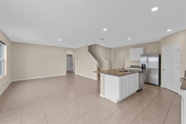 a kitchen with stainless steel appliances granite countertop a sink and a refrigerator