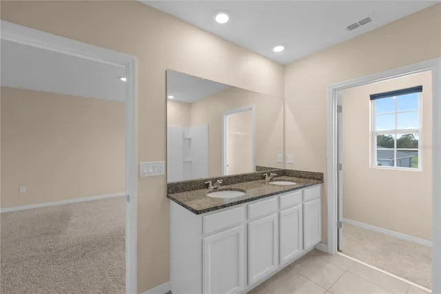 a bathroom with a granite countertop sink and a mirror