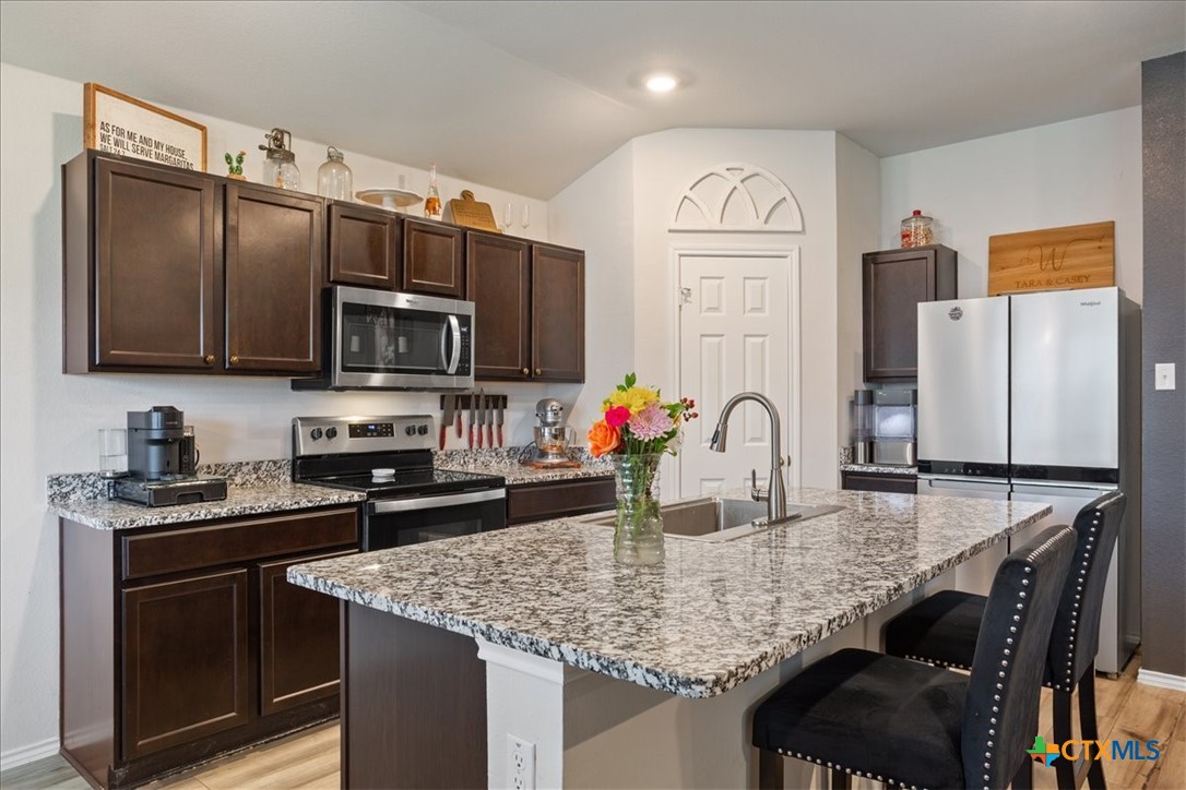 1000 Velvet Court Troy, TX 76579 - Photo 10 of 25 a kitchen with granite countertop a sink stainless steel appliances and cabinets