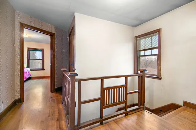 a view of a livingroom with wooden floor and staircase