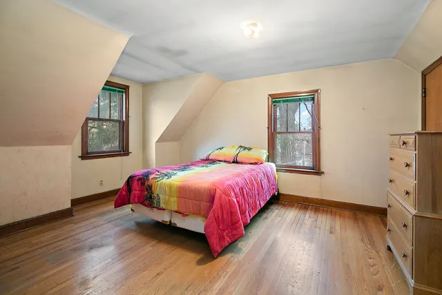 a bedroom with a bed and wooden floor