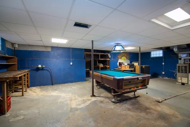 a room with furniture pool table and windows