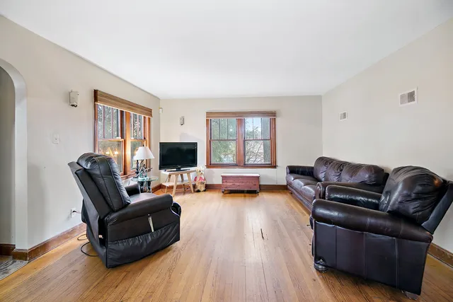 a living room with furniture and a flat screen tv with wooden floor