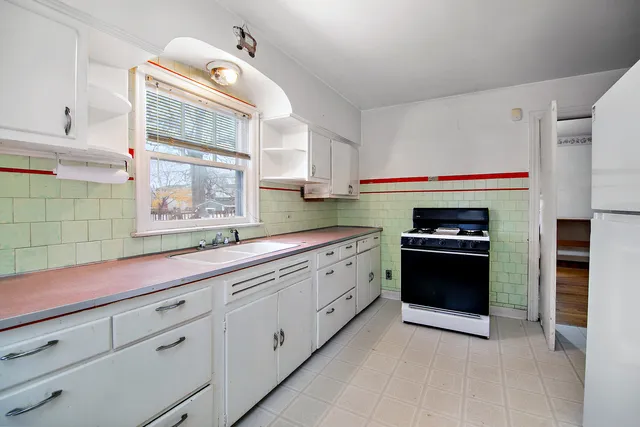 a kitchen with granite countertop white cabinets and stainless steel appliances