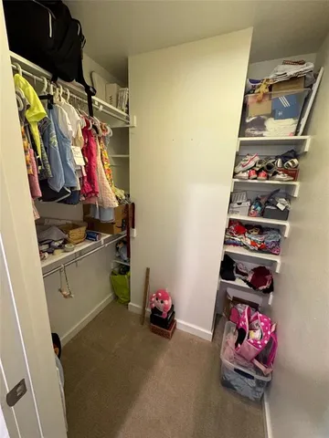 a view of walk in closet with clothes and shoes