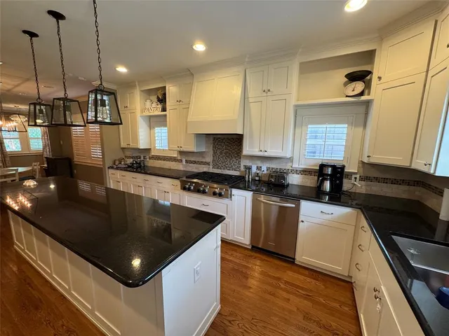 a kitchen with stainless steel appliances granite countertop a sink a stove and a refrigerator