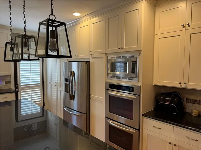a kitchen with stainless steel appliances granite countertop a refrigerator and a stove top oven