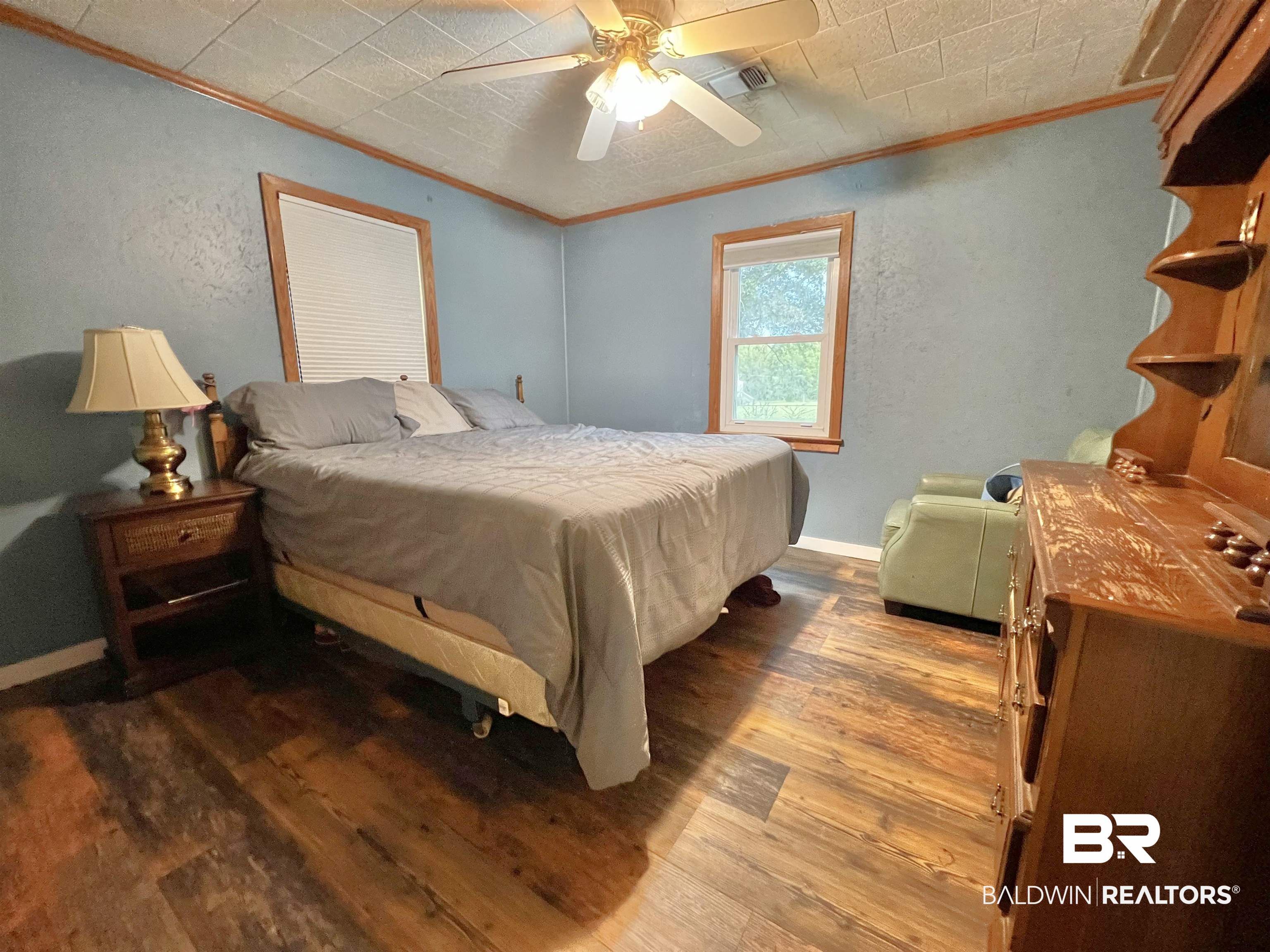 10283 Appleton Road Brewton, AL 36426 - Photo 11 of 18 Bedroom featuring ceiling fan, crown molding, and wood-type flooring
