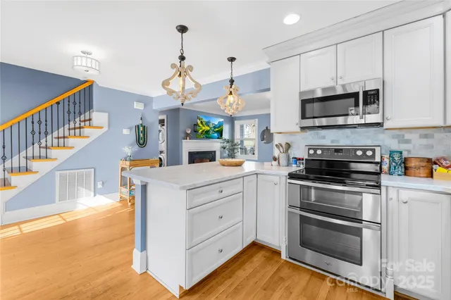 a kitchen with stainless steel appliances granite countertop a stove a sink and a microwave