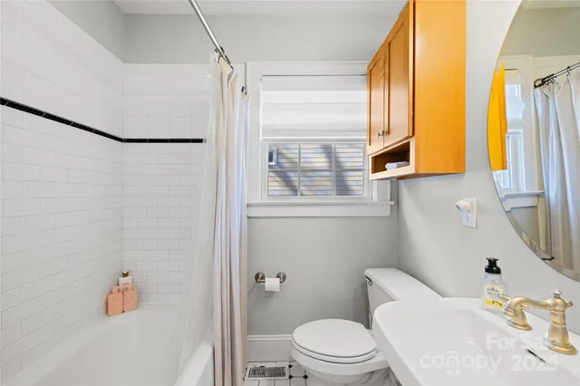 a white toilet sitting next to a bathroom sink and a tub