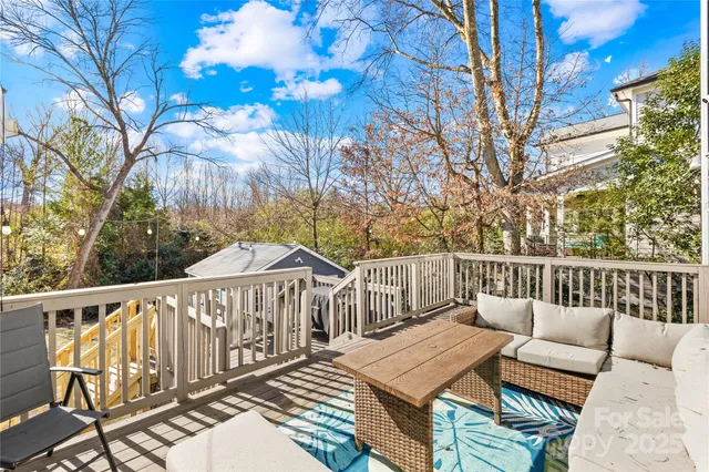 a view of a roof deck with couches and wooden fence