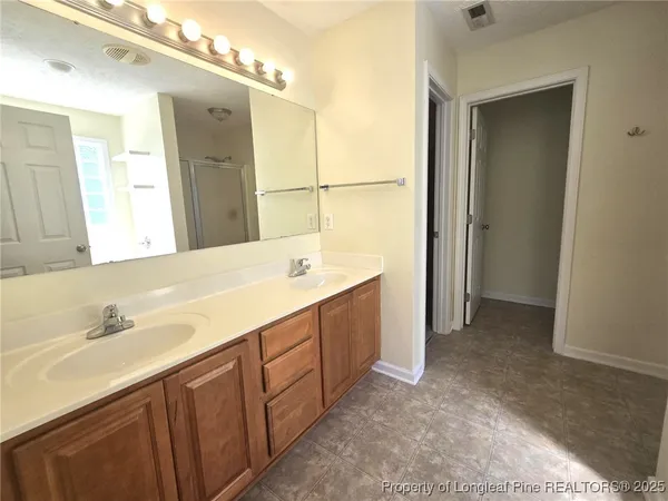 a bathroom with a double vanity sink a mirror and a shower