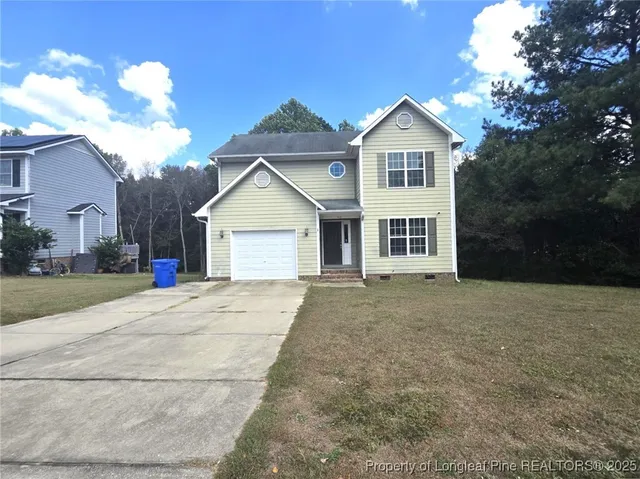 a front view of a house with a yard and garage